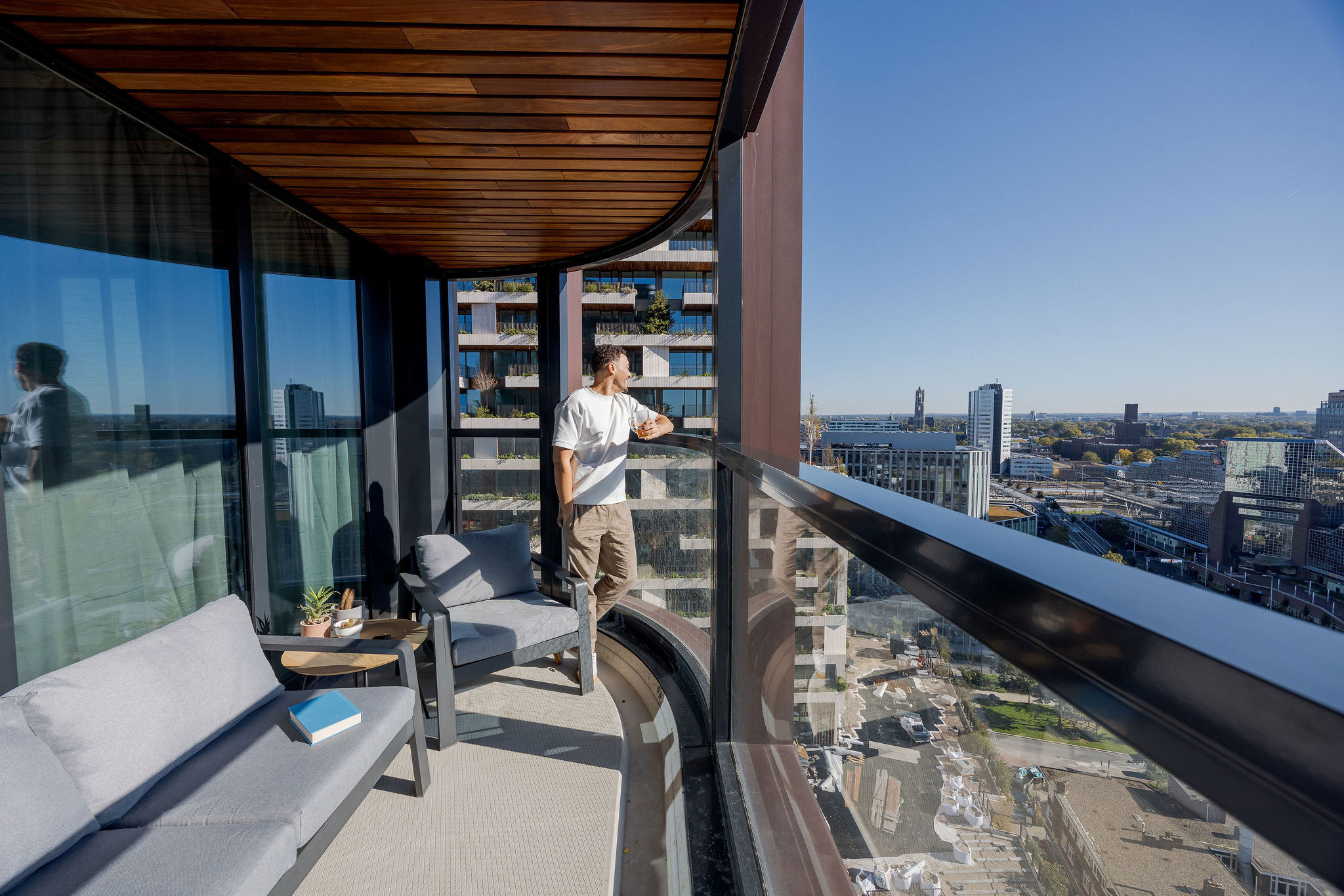 Op deze slide wordt getoond Man kijkt uit op balkon in Wonderwoods.